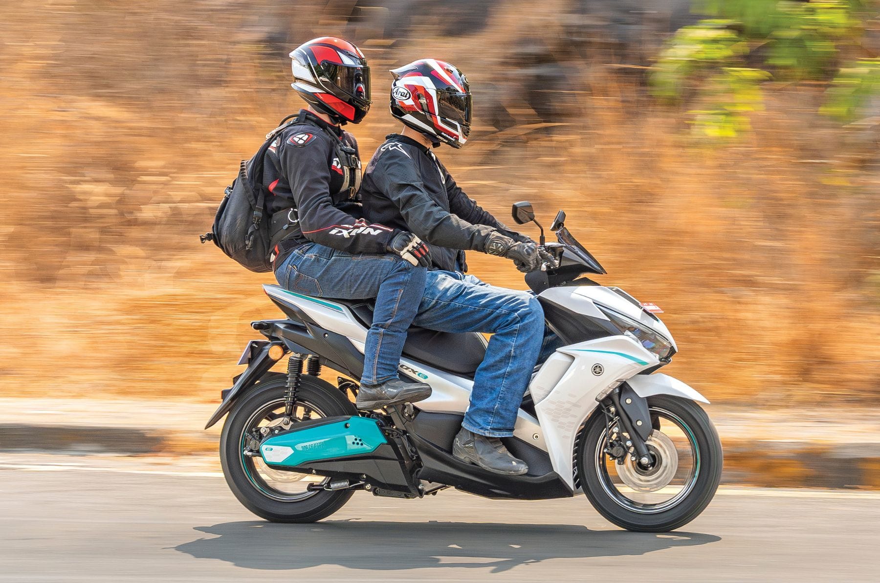 Yamaha Aerox E right side profile shot with rider and pillion