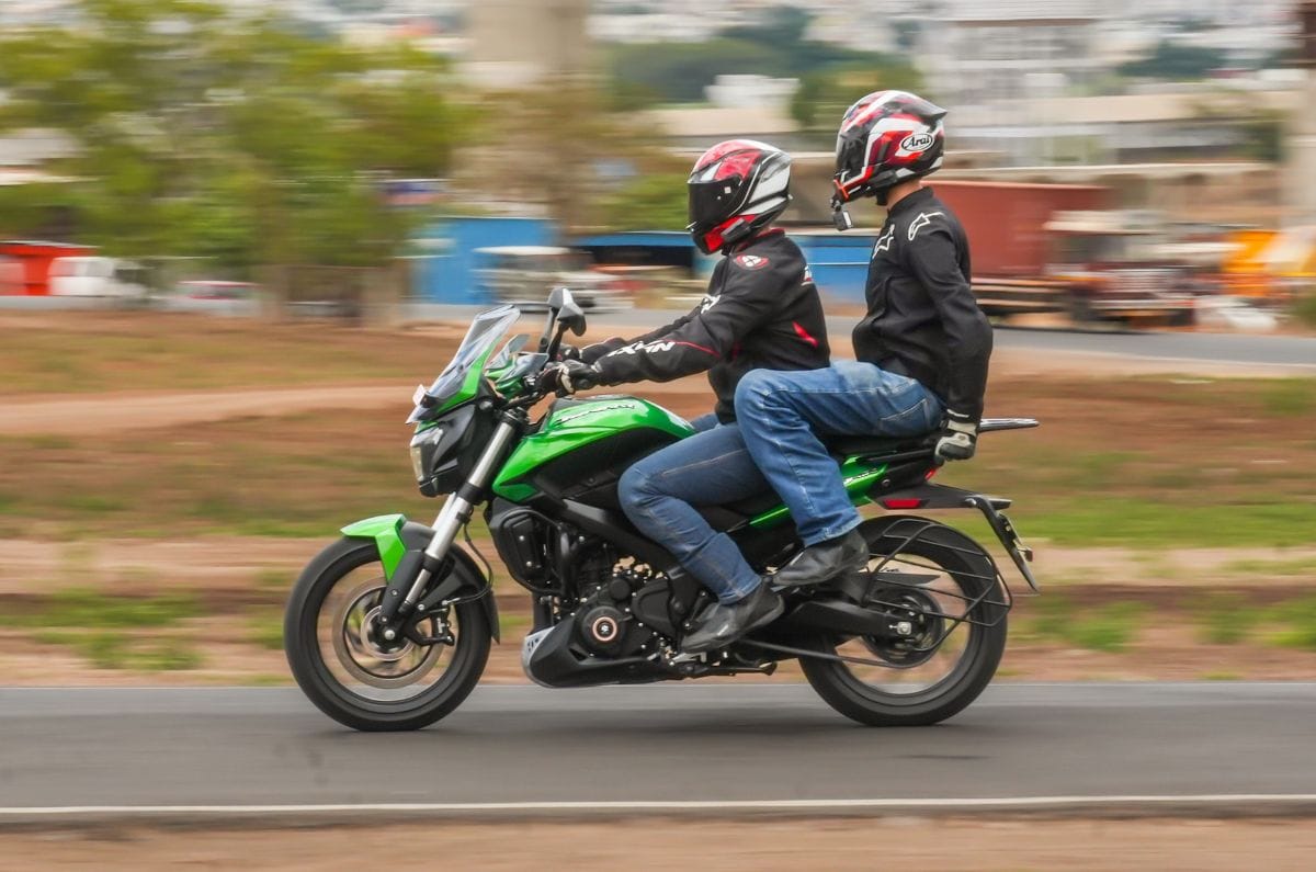 Bajaj Dominar 400 left side profile riding shot on road with two people aboard