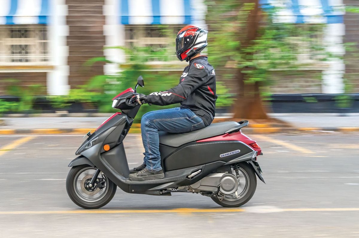 Suzuki e-Access left side profile riding shot on road