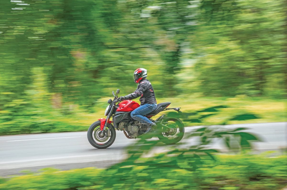 An outside riding \shot showing the Ducati Monster V2's left side
