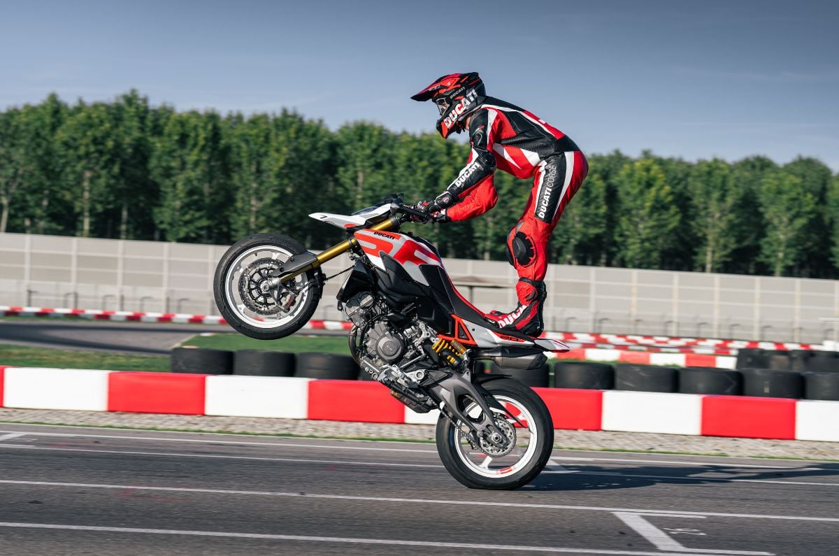 Rider performing a wheelie with both his legs on the Hypermotard's pillion seat.