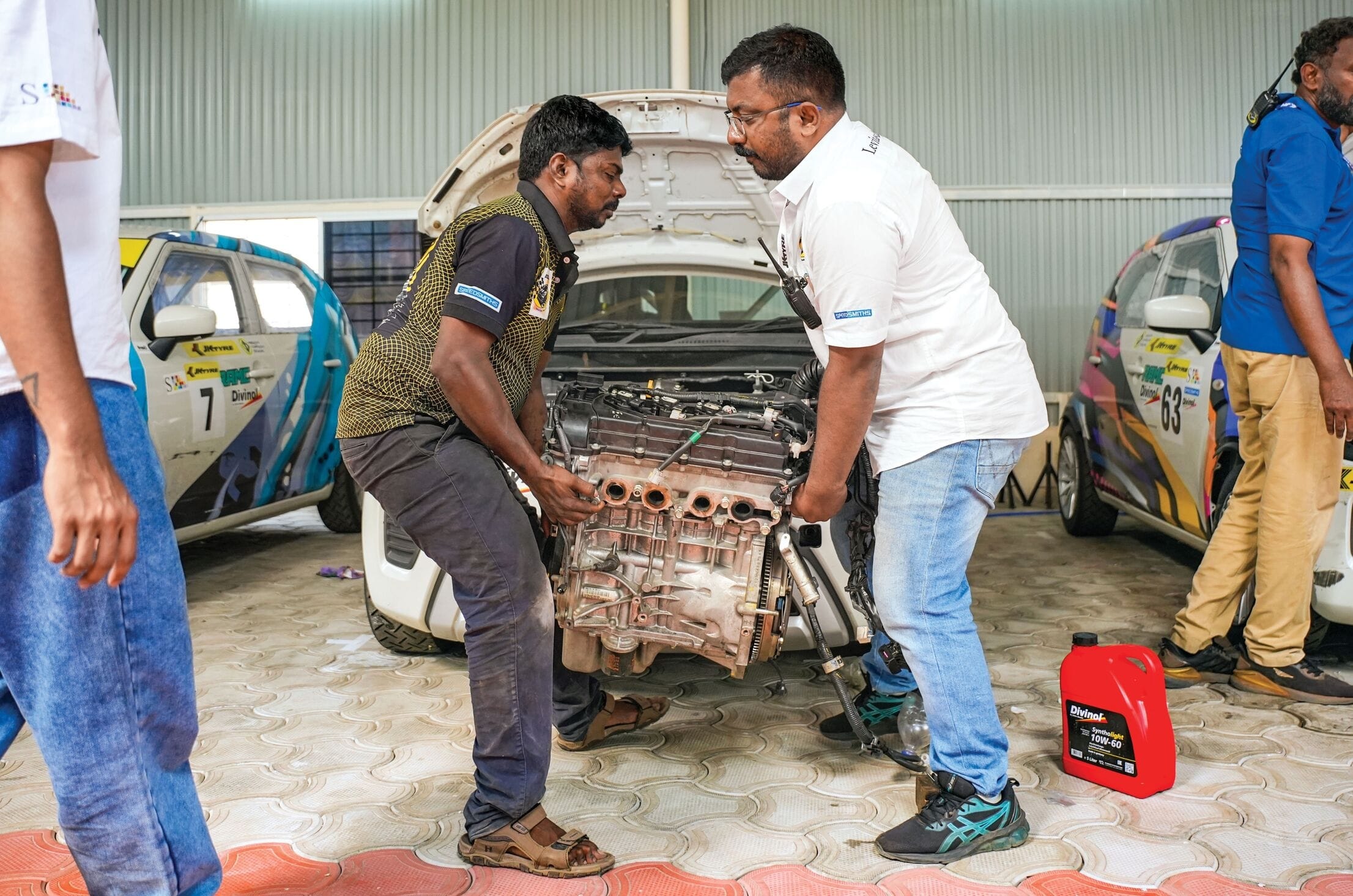 Two people carrying away an engine block.