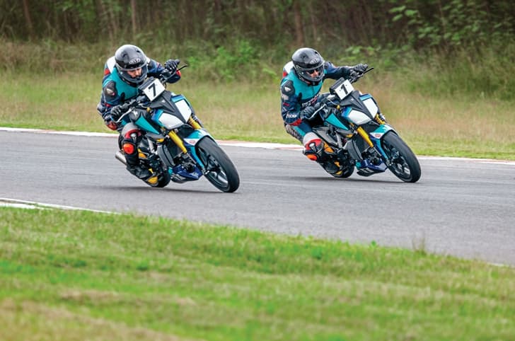 Two riders racing side by side on a racetrack