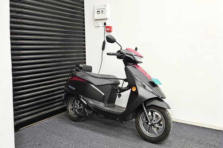 Suzuki e-Access front right side static image in front of shutter