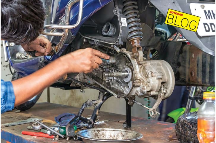 A scooter being serviced at a garage in India