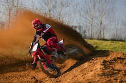 Rider scrubbing a corner in the dirt on the Ducati Desmo450 MX Factory