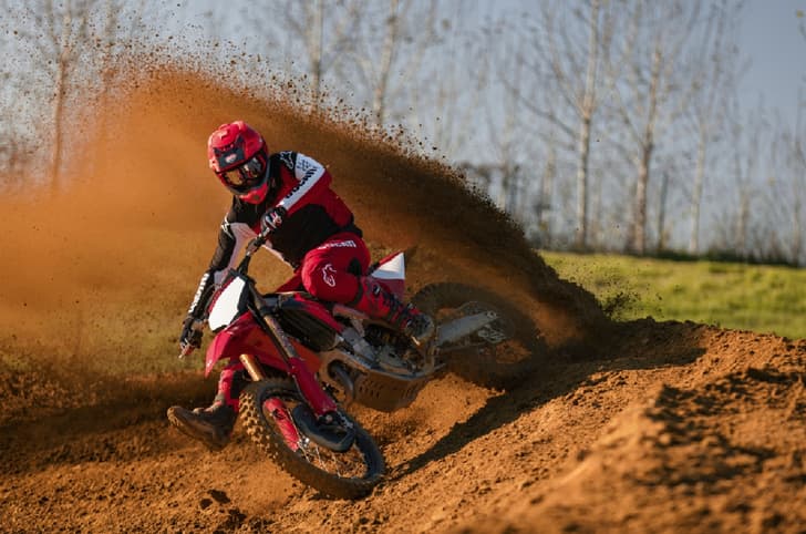 Rider scrubbing a corner in the dirt on the Ducati Desmo450 MX Factory