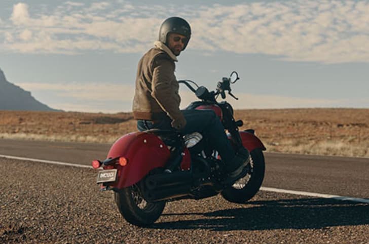 Indian Chief Vintage right side rear static image with rider aboard on highway