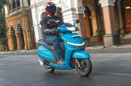Action shot of rider on the Jupiter 110 with urban landscape in the background