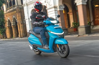 Action shot of rider on the Jupiter 110 with urban landscape in the background