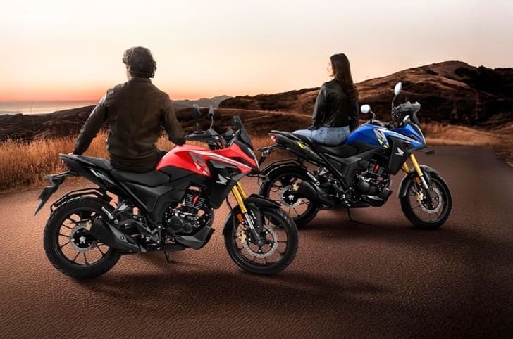 Honda NX200 blue and red bikes parked side by side on hilltop