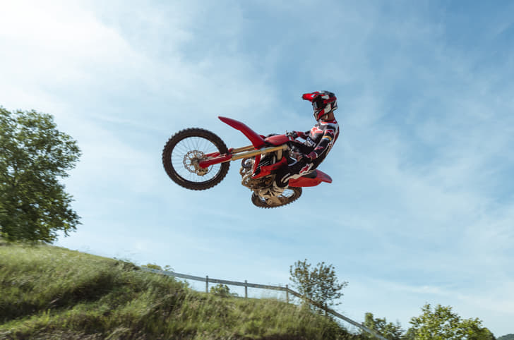 The Desmo250 MX airborne during a jump on a motocross circuit.