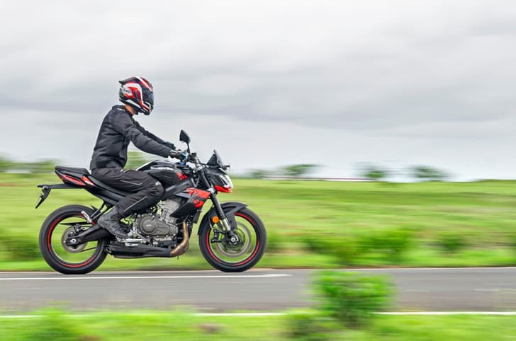An action shot showing a rider on the Aprilia Tuono 457 Special Edition. The bike's right profile is visible with the rider sitting more relaxed than before.