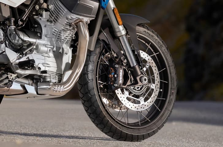 Close up outside shot showing the Moto Guzzi Stelvio's 19-inch front wheel and twin 320mm discs and Brembo monobloc radial calipers.