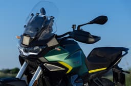 Outside close up image showing the Moto Guzzi Stelvio in Verde Hiking colour. The front radar system that enables the ADAS is prominently lit