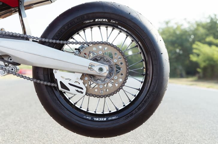 An outside close up image showing the Ducati Desmo450 SM's race slick tyres from Metzeler Racetec.