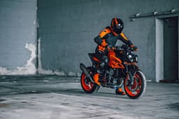 An outside image showing the KTM 990 Duke R's front right quarter profile with a rider on top.