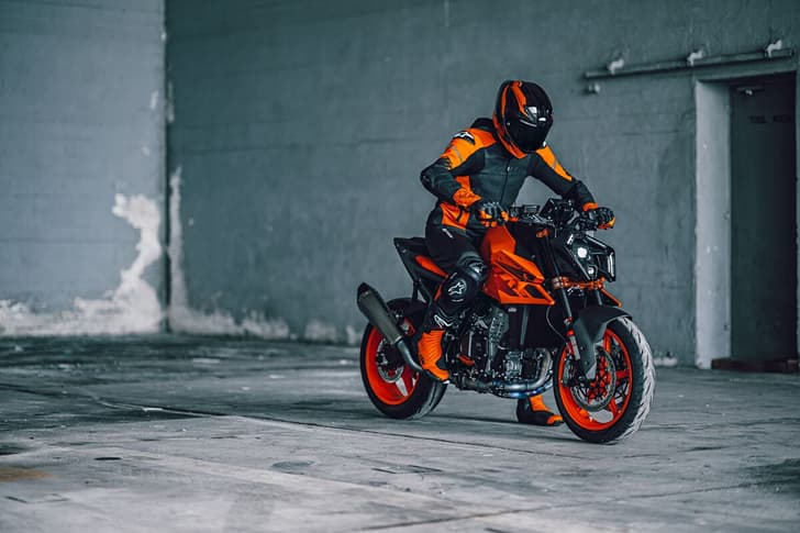 An outside image showing the KTM 990 Duke R's front right quarter profile with a rider on top.