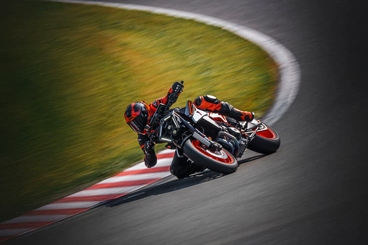 An outside image showing the KTM 990 Duke R performing a right lean at a racetrack.