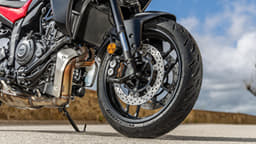 Outside close up image showing the Yamaha Tracer 7's dual front disc brakes and Michelin Road 6 GT tyres.