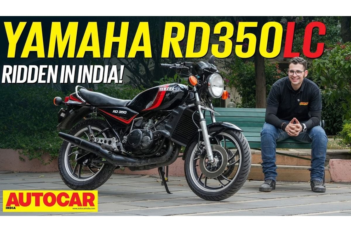 Outside image showing the Yamaha RD350 LC in Black colour with Red highlights alongside host Dinshaw Magol.