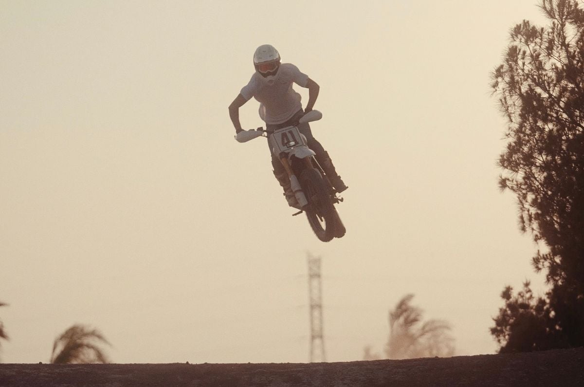 Rider performing a jump on the Triumph Miura, a custom built by Spain's Tamarit motorcycles based on the Scrambler 400 XC.