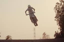 Rider performing a jump on the Triumph Miura, a custom built by Spain's Tamarit motorcycles based on the Scrambler 400 XC.