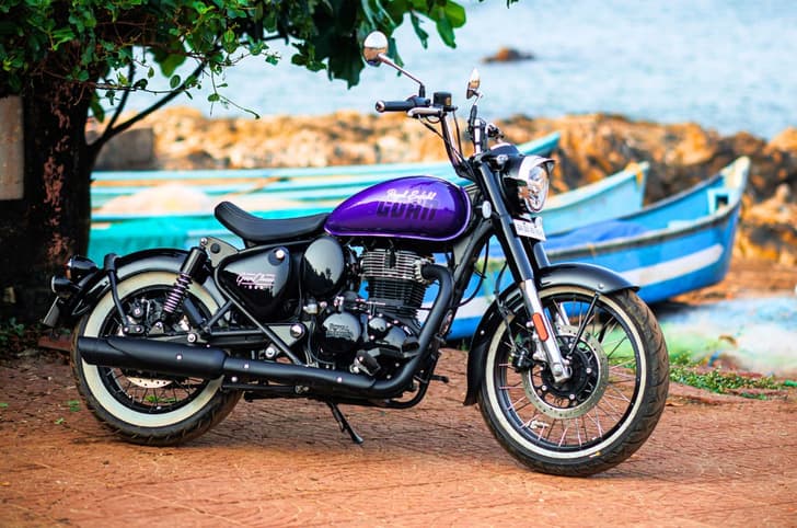 Royal Enfield Goan Classic 350 front right side static image at the beach with boats in the background