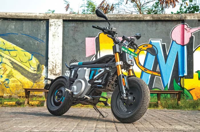 BMW CE 02 parked in front of a wall painted with graffiti