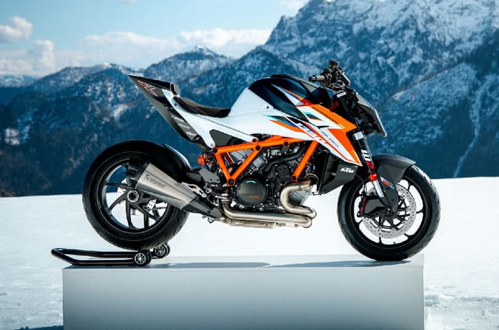 Side profile of the 1390 Super Duke RR on a platform with mountains in the background