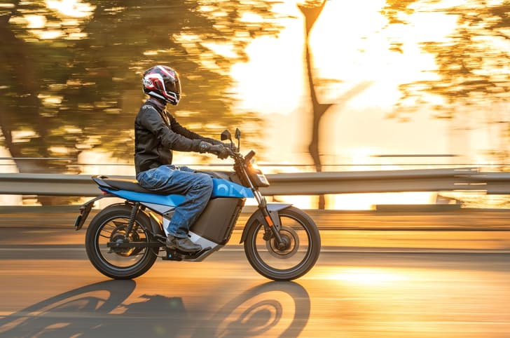 Ola Roadster X+ side profile with sunrays filtering through from the background