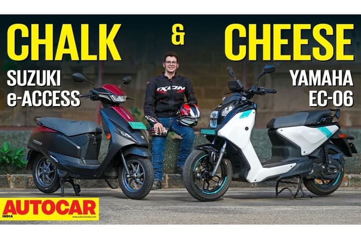 Outside image showing the Suzuki e-Access on the left and the Yamaha EC-06 on the right with the host Dinshaw Magol in the center. Tap to know more.